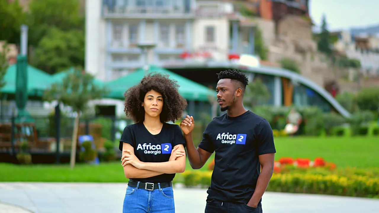Two people in Africa2Georgia T-shirts in a park in Georgia