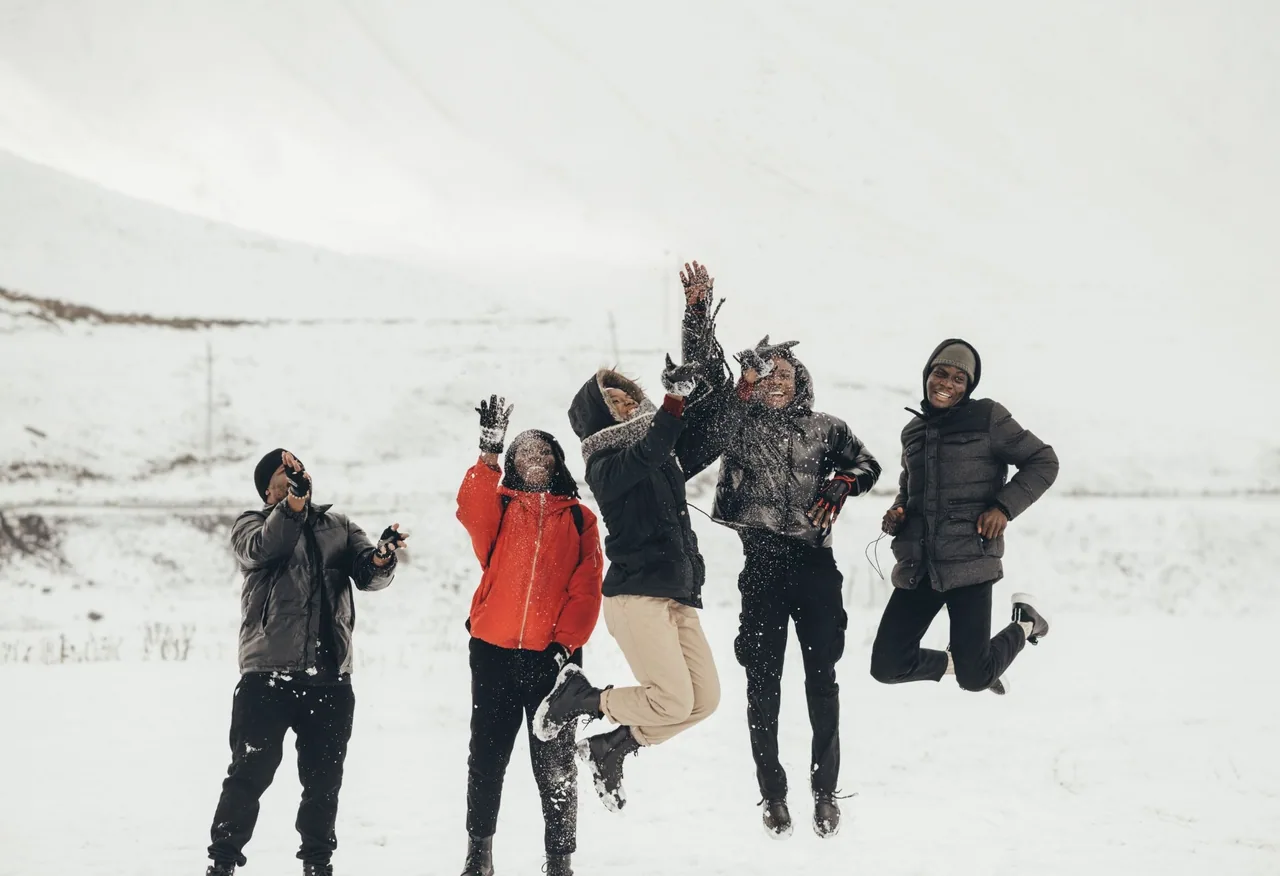 A group of friends jumping in the snow on a winter trip in Georgia